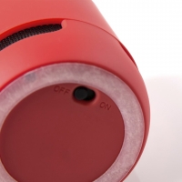Parte trasera de bocina roja, con antideslizante circular, indicador de encendido y apagado. 