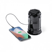 Teléfono cargándose con una lámpara de color negro.
